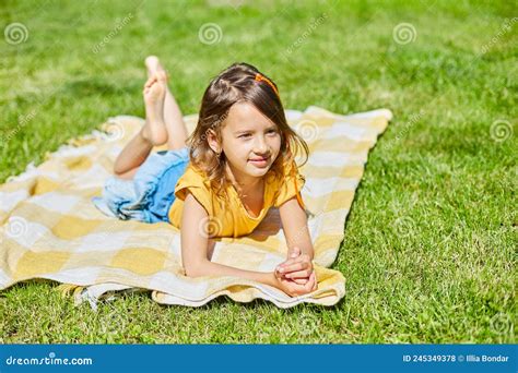 Enfant Allongé Sur La Couverture Sur Lherbe Au Soleil Photo Stock