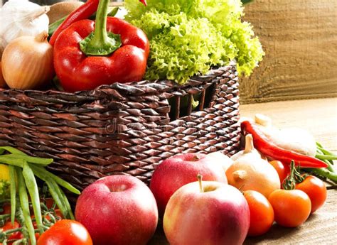 Cesta De Mimbre Con Las Frutas Y Verduras En La Tabla De Madera Imagen