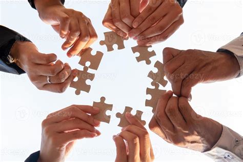 The hand of a businessman holding a paper jigsaw And solving the puzzle ...