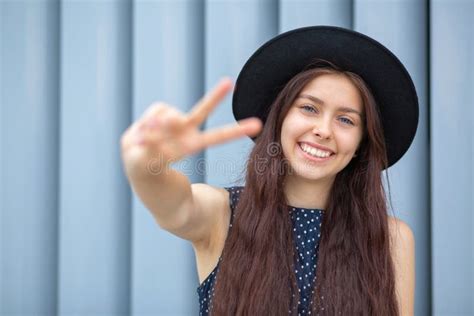 Happy Smiling Brunette Model Wears Hat And Dress Showing Peace Sign With Her Fingers Space For