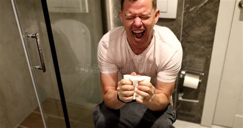 Man Sits On Toilet With Toilet Paper And Suffers From Constipation