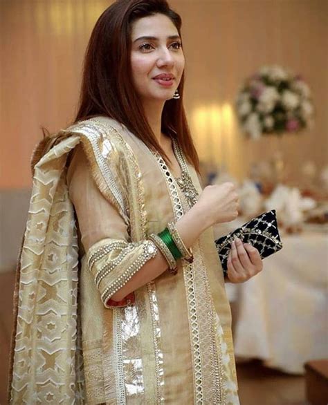 A Woman Standing In Front Of A Table Holding A Purse