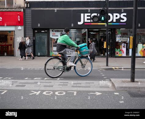 Deliveroo Food Delivery E Bike Riders Jumping Lights On Oxford Street