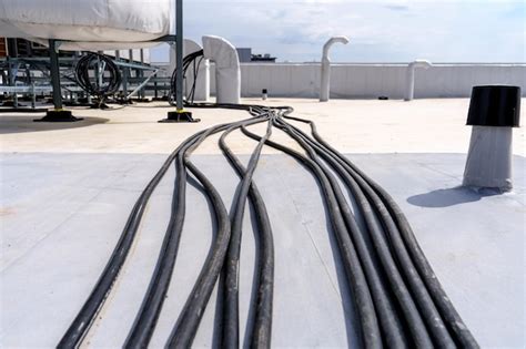 Premium Photo Laying Cables And Wires On The Roof Of An Industrial