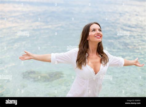 Woman Relaxing At The Beach With Arms Open Enjoying Her Freedom