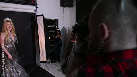 Beautiful Blonde Girl In A Shiny Lush Dress With A Naked Back With A Beautiful Hairstyle And