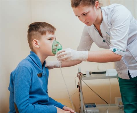 Premium Photo Boy Making Inhalation With Nebulizer At Clinic