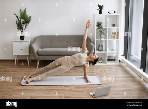Mature Athletic Woman In Tight Sports Clothes Taking Up Side Plank Pose