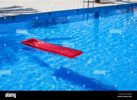 Red Inflatable Lilo Lounger Floating In A Swimming Pool Stock Photo Alamy