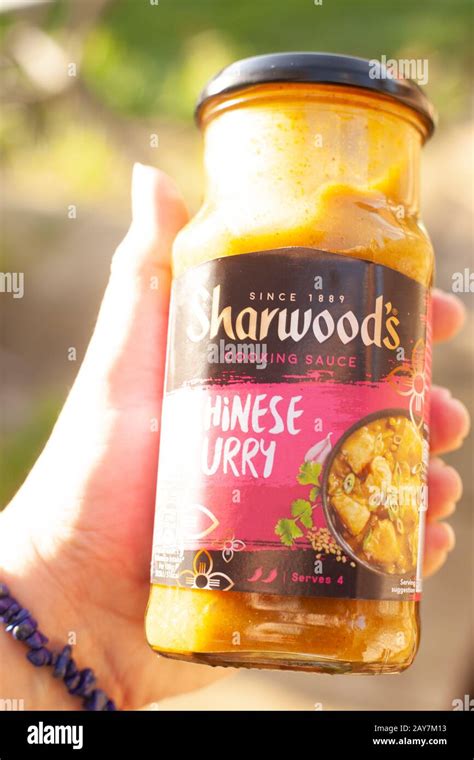 Female Hand Holding A Jar Of Sharwoods Chinese Curry Sauce Against A