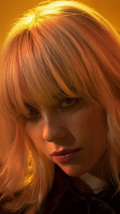 A Woman With Blonde Hair Is Looking At The Camera