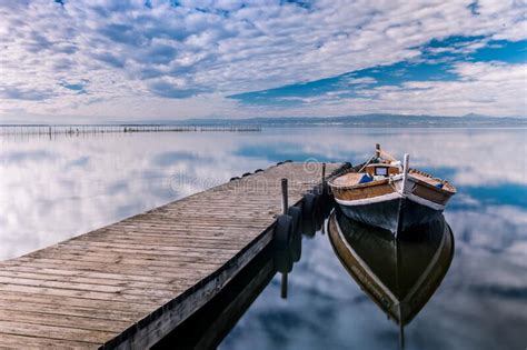 Barco Estacionado Cerca Del Muelle De Madera Con Reflejos En El Mar