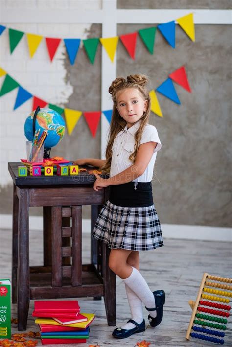 Petite Fille En Uniforme Scolaire Est Assis Avec Un Globe Photo Stock