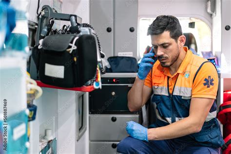 Young And Handsome Paramedic Talking On The Phone Inside An Ambulance