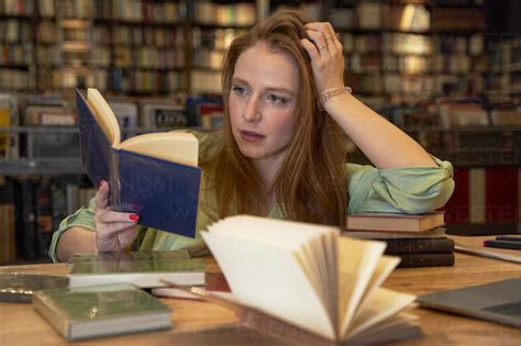 Beautiful Woman Reading Book In Library Stock Photo