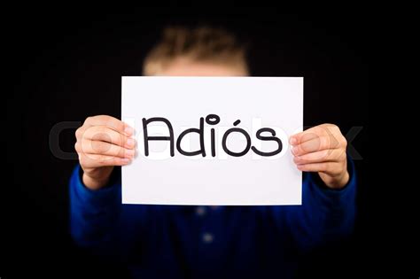 Child holding sign with Spanish word Adios - Goodbye | Stock image ...
