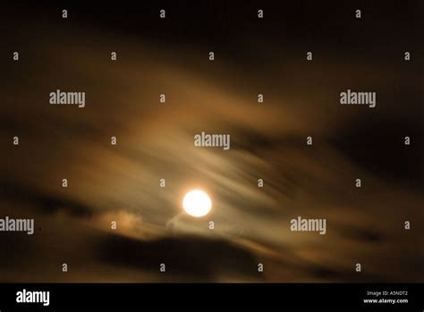 Full Moon Shining Through Clouds At Night Stock Photo Alamy