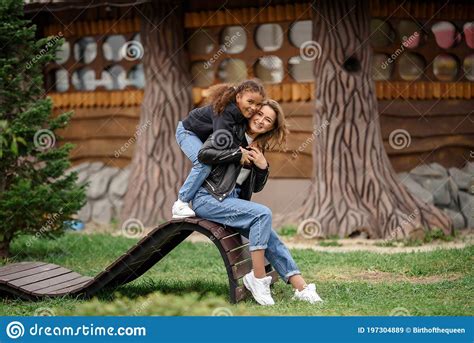 Mother And Adult Daughter Hugging And Having Fun Together In The Park