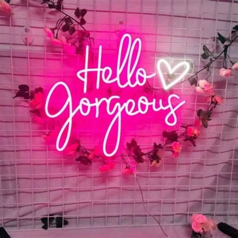 A Pink Neon Sign That Says Hello Gorgeous On The Side Of A Wall Next To