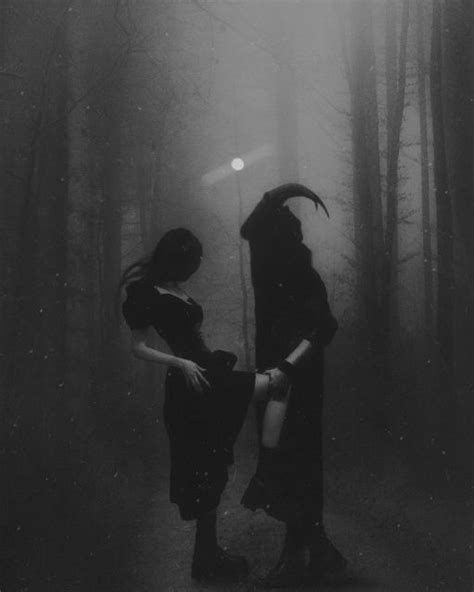 Two Women Dressed As Witches Standing In The Dark Woods With Their