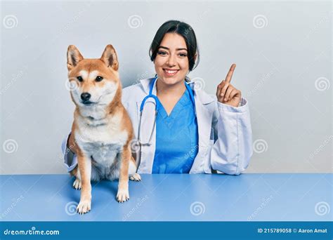 Beautiful Hispanic Veterinarian Woman Checking Dog Health Surprised