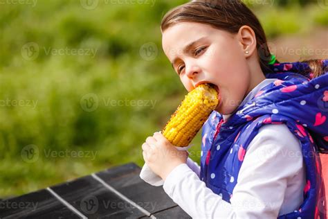 Cute Little Girl Eating Corn In Summertime 16477442 Stock Photo At Vecteezy