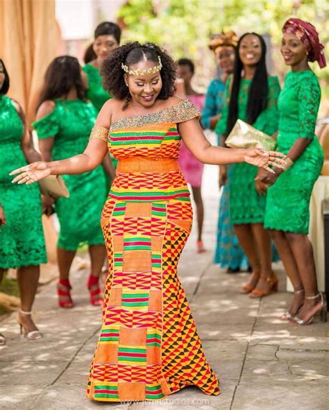 A Woman In An Orange And Green Dress Dancing With Other Women Behind Her On The Sidewalk