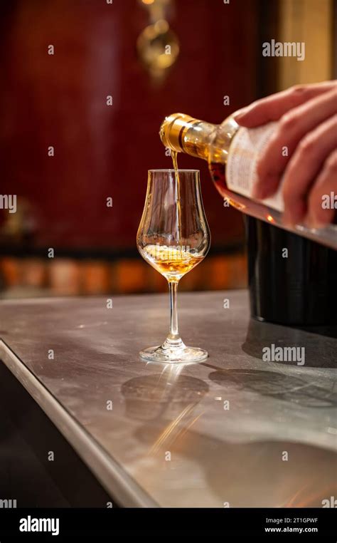 Tasting Of Cognac Spirit Aged In Old Dark French Oak Barrels In Cellar