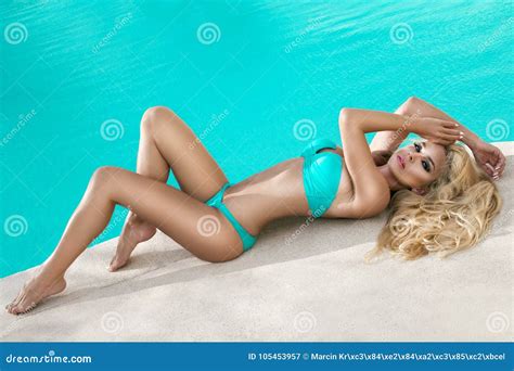 Beautiful Female Blonde Model With A Perfect Body And Amazing Long Hair Lies By The Pool Stock
