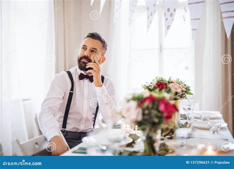 A Portrait Of A Thoughtful Mature Man Sitting Indoors In A Room Set For