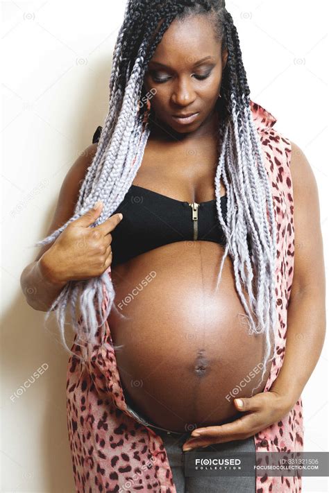 Happy African American Pregnant Woman Holding Hands On Belly Unborn