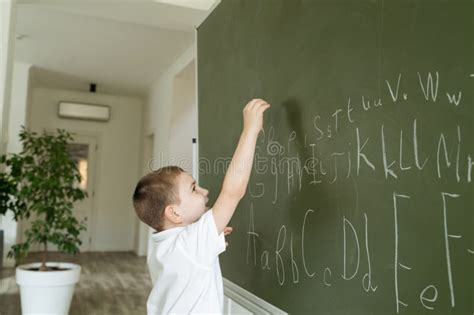 Boy Writing Abc Letters On The Green Chalkboard Stock Image Image Of