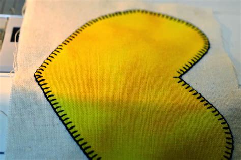 A Yellow And Black Piece Of Fabric On Top Of A White Cloth With A Cell