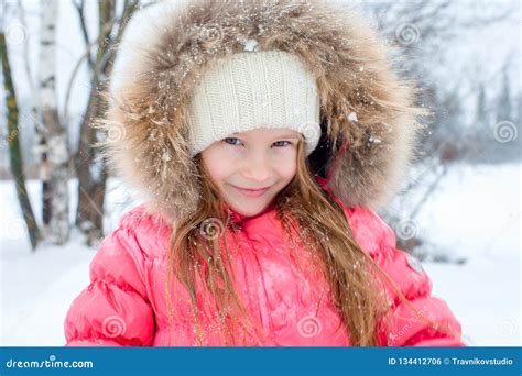 Portrait Of Little Adorable Girl In Snow Sunny Winter Day Stock Photo