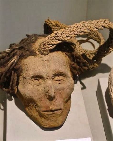 An Old Mask With Dreadlocks On Display In A Museum