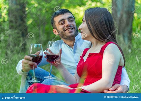 Happy Couple Having Fun In The Park Couple Drinking Red Wine In The