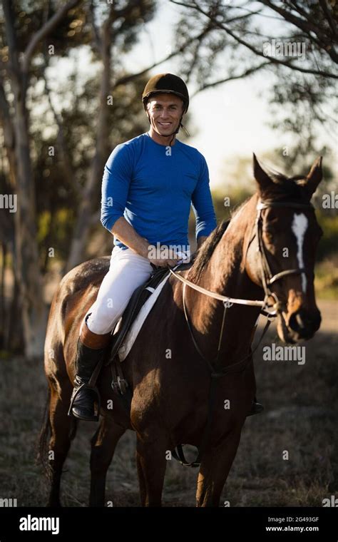 Portrait of male jockey riding horse Stock Photo - Alamy