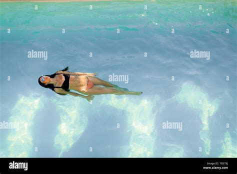 Brunette Caucasian Woman In Bikini Floating In The Pool Water Stock Photo Alamy