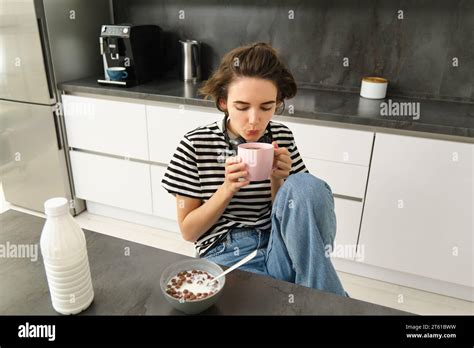 Cute Brunette Woman Student Eating Breakfast In Morning Drinking Hot