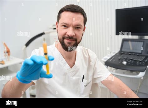 Professional Orthopaedist Posing With A Syringe Full Of Yellow Liquid