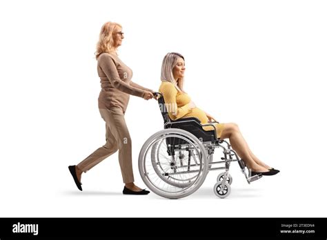 Full Length Profile Shot Of A Mature Woman Pushing A Pregnant Woman In