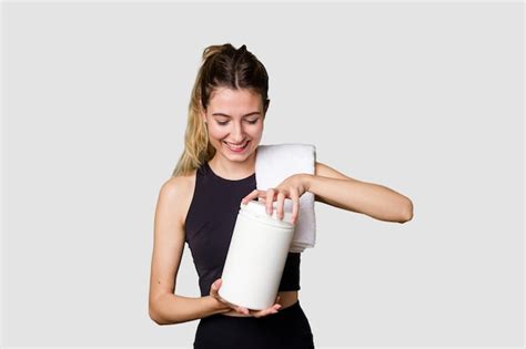 Premium Photo Young Woman Holding A Container Of Protein Powder