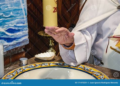 Sacerdote Bendiciendo El Agua Para El Bautismo Imagen De Archivo