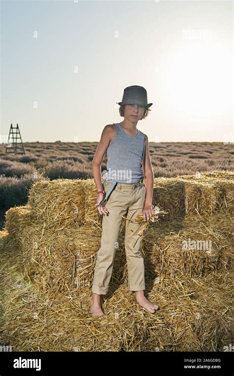 Portrait Of A Barefoot Boy In A Sleeveless Shirt And Trousers With