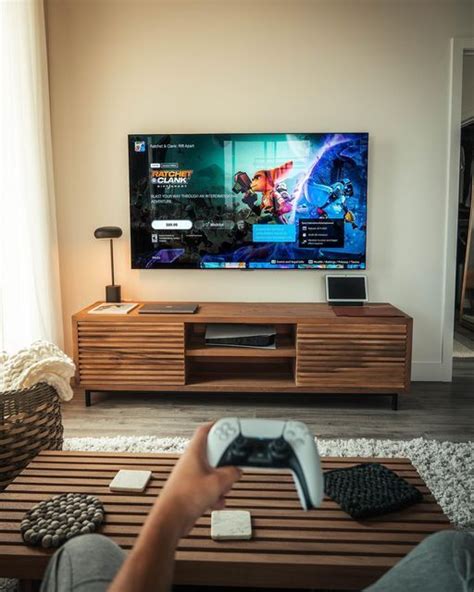 a person sitting in front of a flat screen tv holding a game controller ...