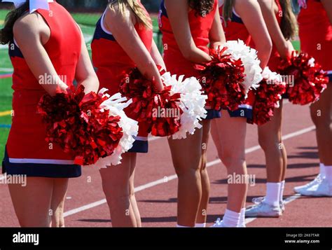 High School Cheerleaders In Red Uniforms Standing On The Sideline