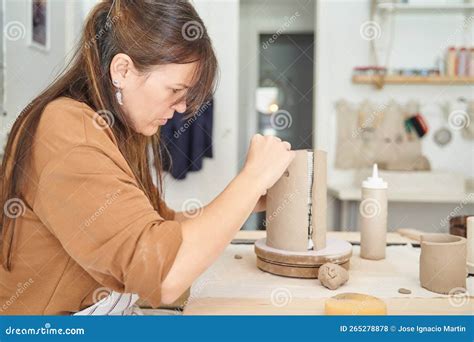 Female Potter Making Handmade Piece With Clay While Working In Pottery