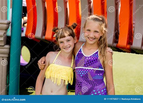 Deux Filles Dans Le Maillot De Bain Ont L Amusement Sur L Herbe Par La