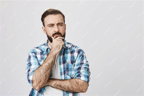 Задумчивый сомнительный бородатый мужчина думает, принимает решение ...