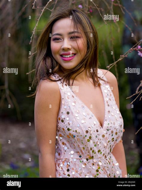 Beautiful Young Woman In Pink Gown Standing Under Blooming Weeping